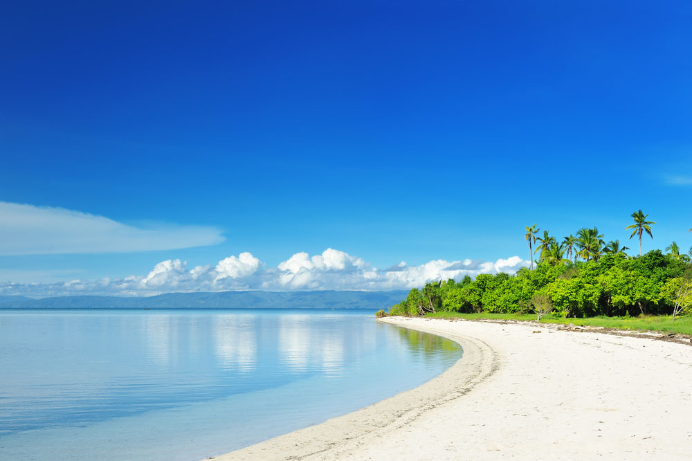 Empty white sand beach with blue skies and clear water, Philippines