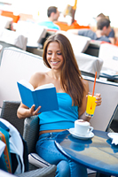 attractive girl reading book in coffee shop