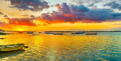 Empty row boat on a golden lake at sunset