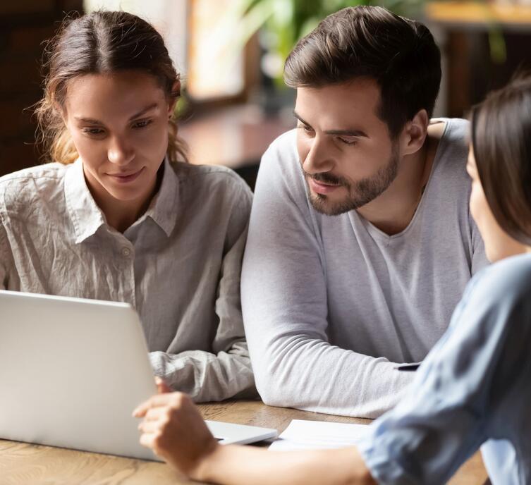 Three people collaborating while looking at a laptop computer screen